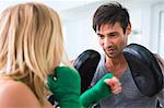 Boxer practicing with trainer in gym