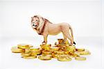 Toy lion on stacks of gold coins
