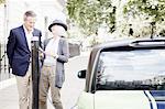 Couple charging electric car on street