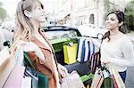 Women loading shopping bags in car