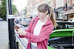 Woman charging electric car on street