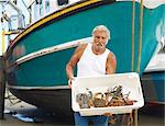 Fisherman holding catch on boat