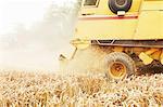 Tractor harvesting grains in crop field