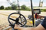 Farmer driving harvester in crop field