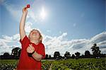 Boy holding strawberry in field