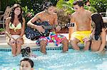 Family relaxing by swimming pool