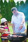 Father and daughter grilling outdoors