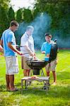 Père et fils, grillades en plein air