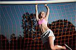 Girl hanging from soccer goal
