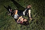 Couple lying on grass at night, high angle