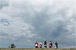 Five friends walking in field, rear view