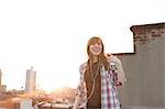 Young woman listening to music on city rooftop