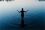 Femme méditant dans le lac paisible