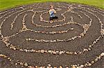 Woman meditating in stone labyrinth