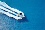 Motor yacht ploughing across blue sea