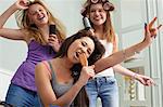 Teenage girls singing into hairbrushes