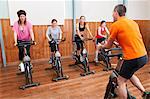 Male instructor and female spinning class