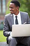 Three-quarter portrait of African American Businessman working on a laptop outdoors