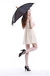 Porträt von schöne junge Frau im Kleid mit Regenschirm vor weißem Hintergrund