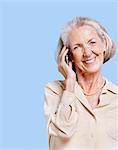 Smiling senior woman using cell phone against blue background