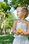 Little girl holding flower outdoors