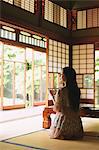 Japanese woman drinking green tea in a traditional Japanese house