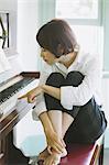 Japanese woman in a white shirt playing the piano