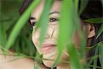 Young woman behind foliage, portrait