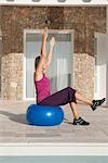 Young woman doing exercise on fitness ball