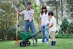 Father and two children working together in yard