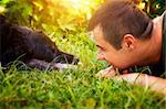 Friends concept. Man and labrador retirever dog are lying in summer grass