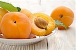 Apricots on the plate on a wooden background