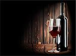 Rotwein mit einem Glas Wein auf hölzernen Hintergrund