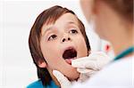 Say aaah - little boy having his throat examined by health professional - closeup