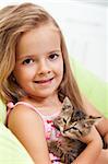 Little girl holding her kitten - shallow depth of field, closeup