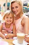Mother And Daughter Enjoying Cup Of Coffee And Piece Of Cake In Caf?