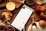Baking concept background with paper for notes. Christmas and winter  cookies ingredients.Baking pastry and cookies: apples, spices, sugar, eggs on wood