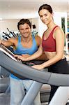 Woman Working With Personal Trainer On Running Machine In Gym