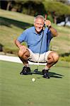Senior golfeur masculin sur Putt Up doublure de golf sur le Green