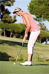 Leitende weibliche Golfer am Golfplatz Futter bis Putt auf grün