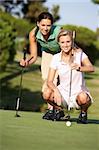 Zwei weibliche Golfer am Golfplatz Futter bis Putt auf grün
