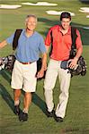 Deux hommes marchant le long de Golf cours sacs de transport