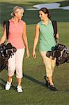 Zwei Frauen entlang Golf Kurs Buchwerte Taschen