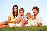 Young parents, with children, posing on a field