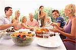 A family, with parents, children and grandparents, enjoy a picnic