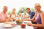 Extended family, parents, grandparents and children, eating outdoors