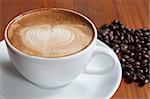 Coffee cup and beans on a wood table