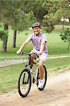 Senior man enjoying bike ride in park