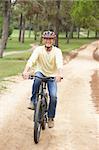 Senior man riding bicycle in park