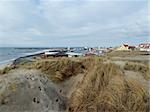 littoral nord Danemark avec maisons, l'herbe et ciel nuageux